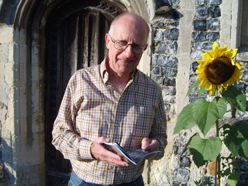 Clive outside one of the churches beside a sunflower.
